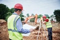 Construction workers on building area. Foreman with blueprint and surveyoor Royalty Free Stock Photo
