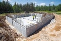 construction workers building a concrete block foundation for a new house surrounded by forest and clear blue sky outdoors Royalty Free Stock Photo