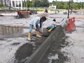 Construction workers creating concrete road curb at the construction site.