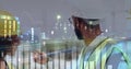 Construction workers discussing project plans with financial data overlay at night