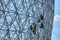 Construction workers doing maintenance job on the steel bars of the biosphere environment museum in Montreal, Quebec, Canada