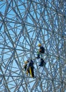 Construction workers doing maintenance job on the steel bars of the biosphere environment museum in Montreal, Quebec, Canada