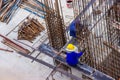 Construction workers fabricating large steel bar reinforcement bar at the in construction area building site Royalty Free Stock Photo