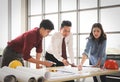 Construction workers , a female architech and two male engineers discussing about the project at office table indoor Royalty Free Stock Photo