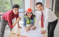 Construction workers , a female architect and two male engineers discussing about the project at office table indoor,smiling and Royalty Free Stock Photo