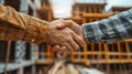 Construction Workers Handshake in Front of Building Under Construction Royalty Free Stock Photo
