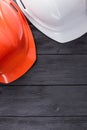 Construction workers helmets on dark wood. Royalty Free Stock Photo