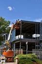 Construction workers high on a hydraulic lift at building site.