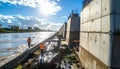 Construction workers inspect a concrete flood control structure along river Royalty Free Stock Photo