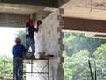Construction workers installing lightweight block bricks to become wall at the construction site. Royalty Free Stock Photo