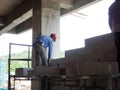 Construction workers installing lightweight block bricks to become wall at the construction site. Royalty Free Stock Photo