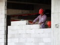 Construction workers installing lightweight block bricks to become wall at the construction site. Royalty Free Stock Photo