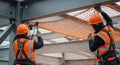 Construction Workers Installing Metal Mesh on a Steel Beam Structure with Safety Gear and Protective Equipment Royalty Free Stock Photo