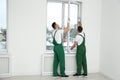 Construction workers installing plastic window