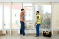 Construction workers installing plastic window