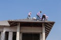 Construction workers installing roof tiles for home building