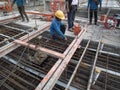 Construction workers are installing steel rods in reinforced concrete post tension site concrete steel