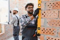 Construction workers installing window and checking wall with spirit level Royalty Free Stock Photo