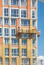 Construction workers insulating house facade with mineral rock wool installation.