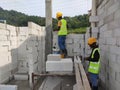 Construction workers laying autoclaved aerated concrete block at the construction site.