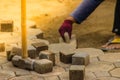 Construction workers are laying concrete pavement stone for footpath work at the construction site. Paving stone worker is putting Royalty Free Stock Photo