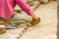 Construction workers are laying concrete pavement stone for footpath work at the construction site. Paving stone worker is putting Royalty Free Stock Photo