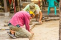 Construction workers are laying concrete pavement stone for footpath work at the construction site. Paving stone worker is putting Royalty Free Stock Photo