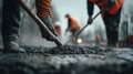 Construction workers leveling wet cement on road surface for paving project in urban area scene Royalty Free Stock Photo