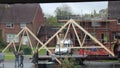 Construction workers moving roof beams.