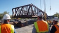 Construction Workers Observing a Bridge Section Being Lifted by a Crane Royalty Free Stock Photo