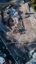 Construction workers and heavy machinery are working on the foundations of a new building on a large construction site, viewed Royalty Free Stock Photo