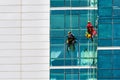 Construction workers performing maintenance or repair on the facade of a building. Royalty Free Stock Photo
