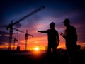 Construction workers planning progress at building site sunset Royalty Free Stock Photo