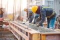 Construction Workers Pouring Concrete into Beam Formwork on Site Royalty Free Stock Photo