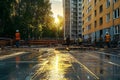 construction site workers in safety gear working on concrete foundation near residential building during sunset Royalty Free Stock Photo