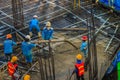 Construction workers are pouring concrete in post-tension flooring work. Mason workers carrying hose from concrete pump or also k