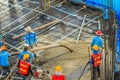 Construction workers are pouring concrete in post-tension flooring work. Mason workers carrying hose from concrete pump or also k Royalty Free Stock Photo