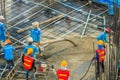 Construction workers are pouring concrete in post-tension flooring work. Mason workers carrying hose from concrete pump or also k