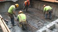 Construction workers pouring concrete into a rebar grid Royalty Free Stock Photo