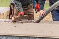 Construction Workers Pouring And Leveling Wet Cement Into Wood Framing Royalty Free Stock Photo