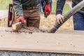 Two Construction Workers Pouring And Leveling Wet Cement Into Wood Framing Royalty Free Stock Photo