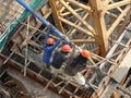 Construction workers pouring wet concrete using concrete spider hose