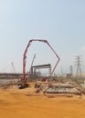 construction workers at the project site are casting using a concrete pump