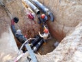 Construction workers risk their lives working inside deep trenches to install underground services pipe.