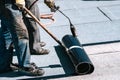 Construction workers, roofers installing rolls of bituminous waterproofing membrane for the waterproofing of new house. House Royalty Free Stock Photo