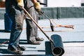 Construction workers, roofers installing rolls of bituminous waterproofing membrane for the waterproofing of new house. House Royalty Free Stock Photo