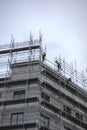 Construction workers on scaffolding high up on commercial building Royalty Free Stock Photo