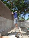 Construction workers are smoothing the walls with aggregate of cement, sand, water