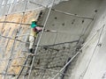 Construction workers are spraying liquid concrete onto the slope surface to form a retaining wall layer.