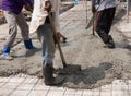 Construction workers spreading freshly poured concrete mix for home building